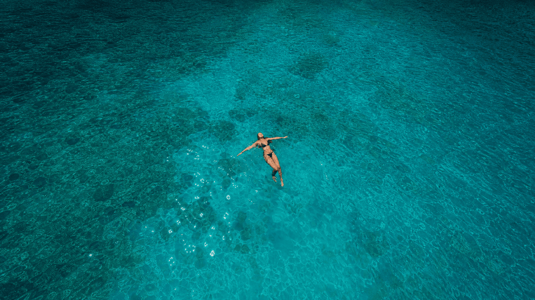 bbq-woman-floating-turquoise-water-aerial